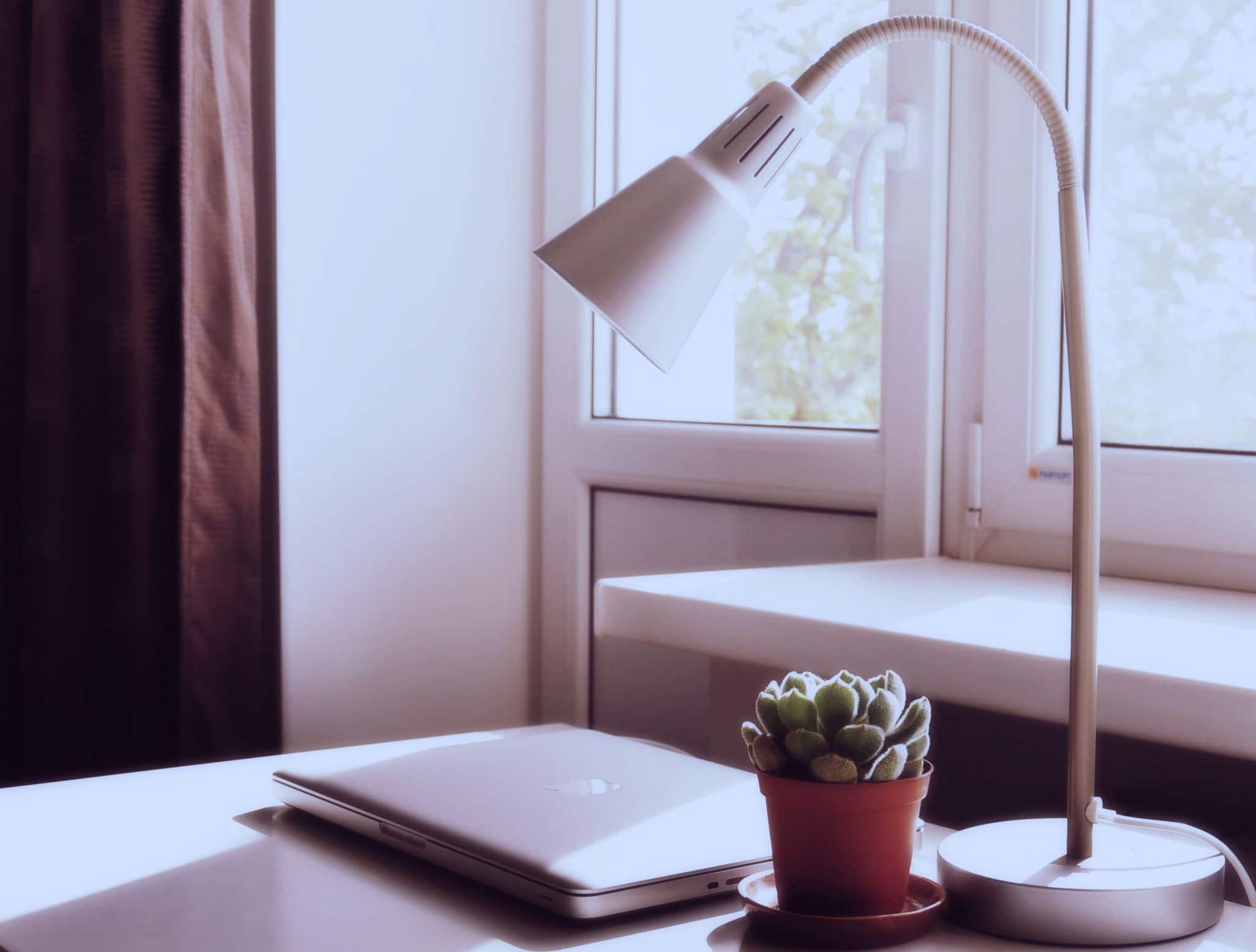 How to Improve Your Home Office Lighting. Desktop with adjustable lamp in the casual minimalistic interior