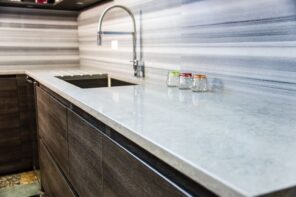 Laminate vs. Quartz Countertops: What is the Price Difference. Gray countertop and splashback for modern-style minimalistic kitchen