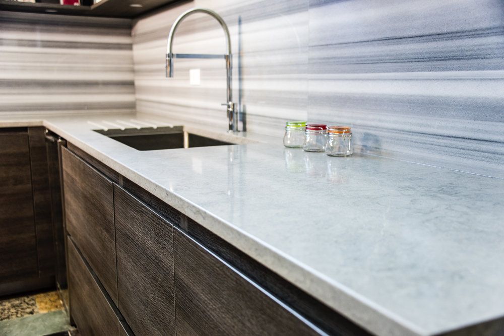 Laminate vs. Quartz Countertops: What is the Price Difference. Gray countertop and splashback for modern-style minimalistic kitchen