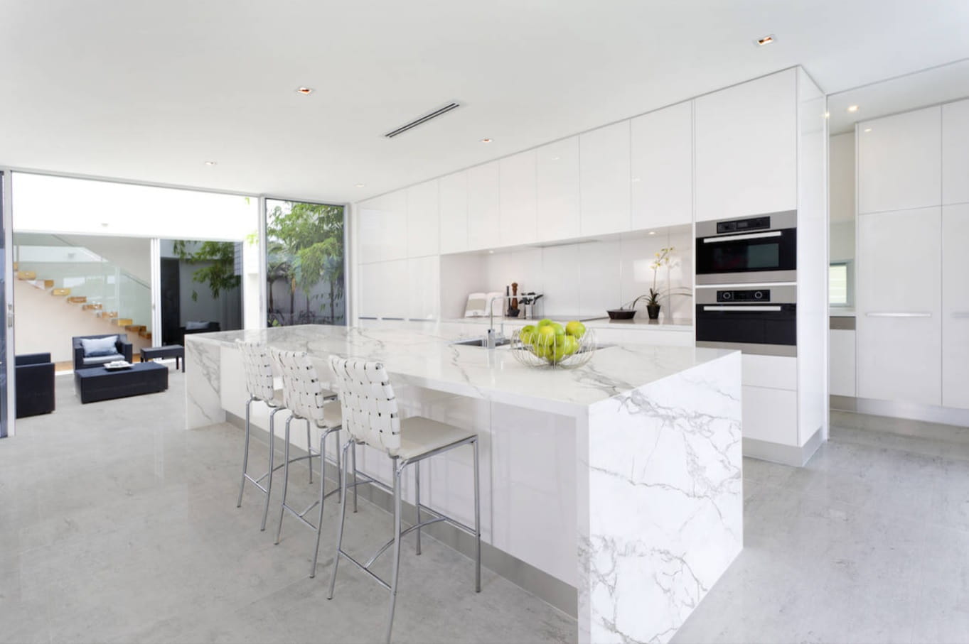 Reasons Why Concrete is the Best Flooring Alternative to Your Homes. Spacious modern kitchen interior design with white cabinets and marble streaks at the central island