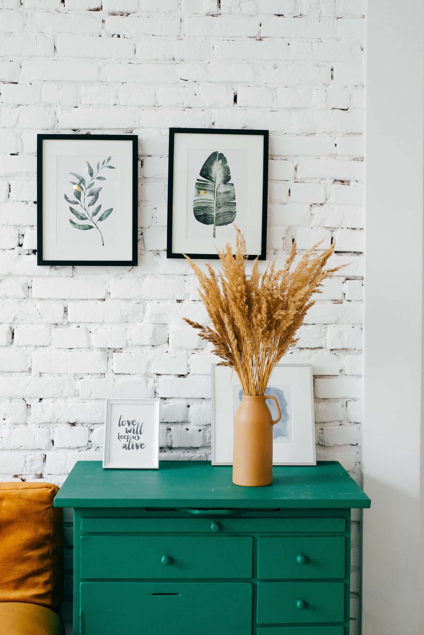 Guide to Choosing the Perfect Wall Art. Whitewashed wall with photo and plant decorations