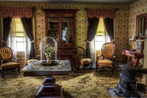 Expert Decorating Tips to Give Your Home a Vintage Look. Ancient looking living room with beige wooden furniture and upholsterings and gilded wallpaper