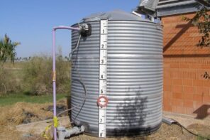 Why Should You Invest in Rainwater Tanks for Your Home? Metal rainwater tank with tags and plumbing