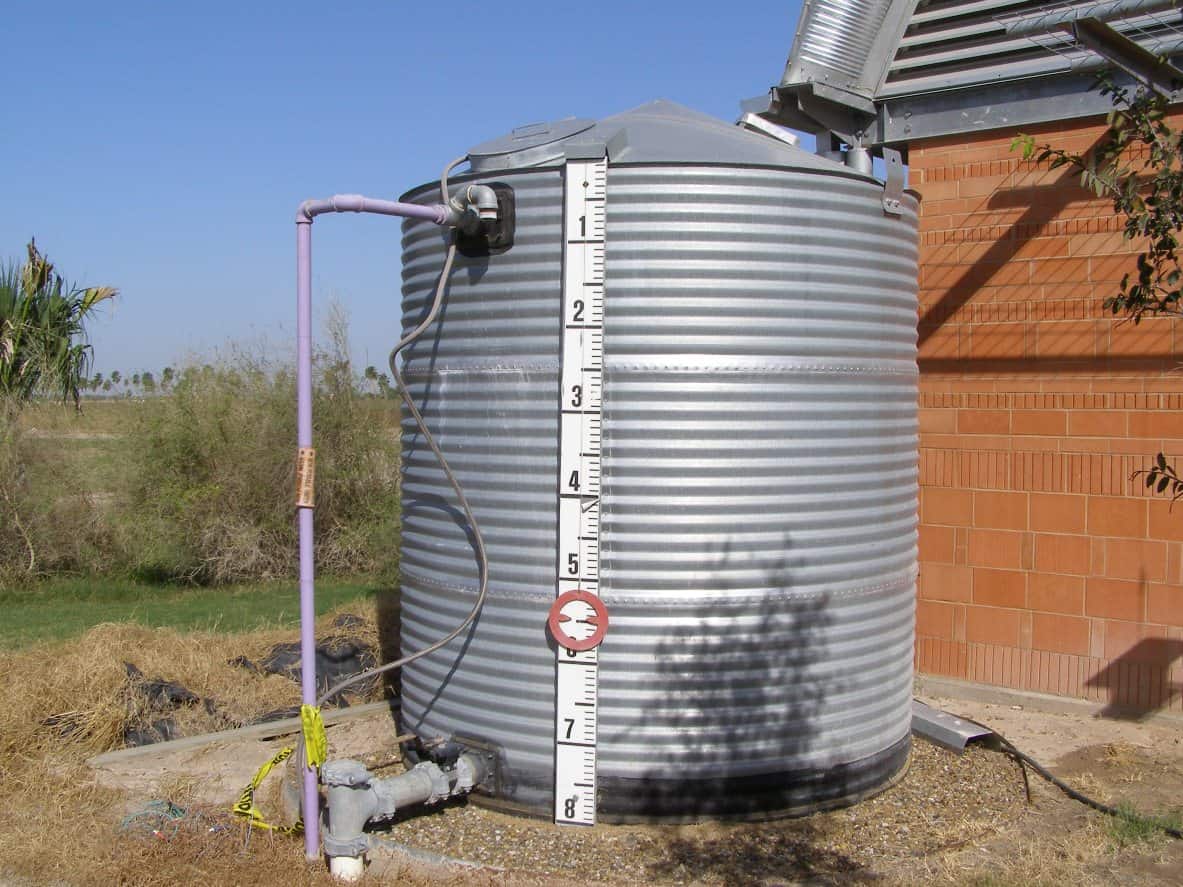 Why Should You Invest in Rainwater Tanks for Your Home? Metal rainwater tank with tags and plumbing