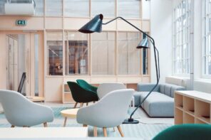 Portable Walls in the Interior of the Modern Apartment. Wooden and glass wall for delimiting the large Scandinavian styled space with large floor lamps and plastic chairs