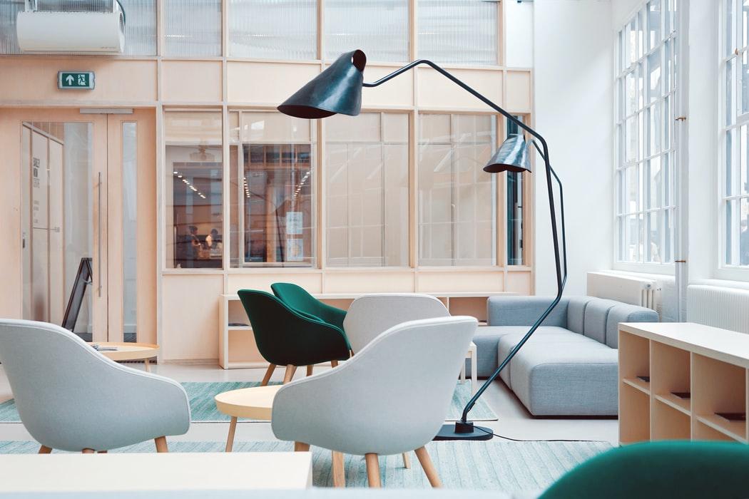 Portable Walls in the Interior of the Modern Apartment. Wooden and glass wall for delimiting the large Scandinavian styled space with large floor lamps and plastic chairs