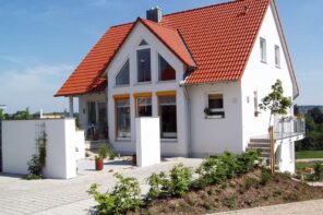 Choosing the Best Roofing Option for a Tiny Home. Nice red ceramic shingles at the top of the white facaded private house