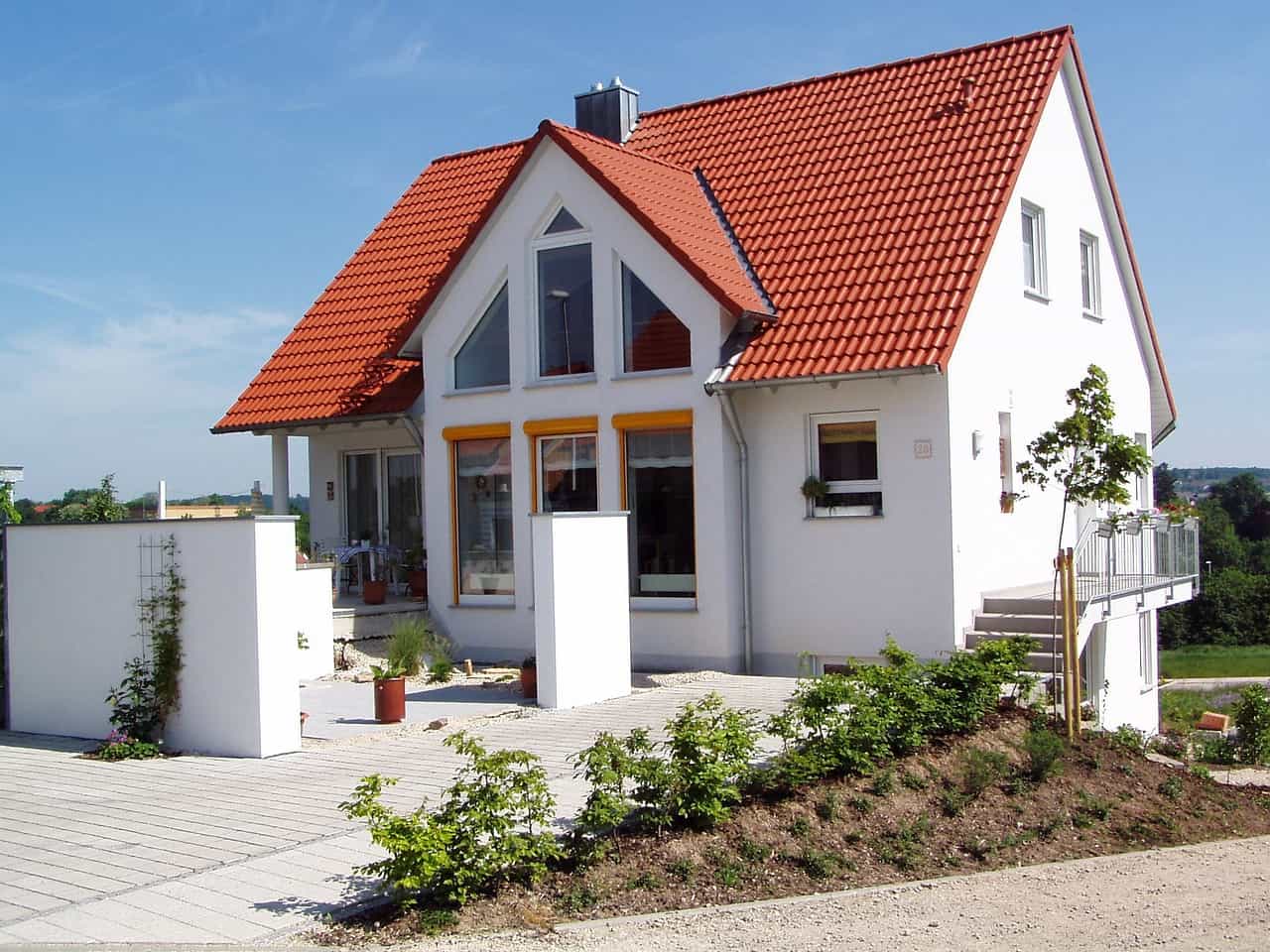 Choosing the Best Roofing Option for a Tiny Home. Nice red ceramic shingles at the top of the white facaded private house