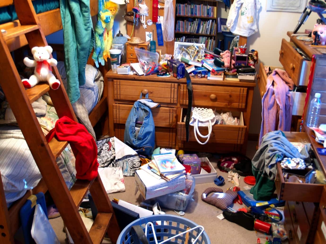 It’s Time to Let Go. Learn How to Get Rid of Clutter Fast! Stuffed and littery dorm room with bunk bed and old wooden dresser
