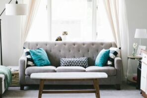 Important Things To Keep In Mind When Choosing Furniture For Your Living Room. Gray quilted sofa with turquoise pillows and gray topped wooden coffee table for the casual-style interior