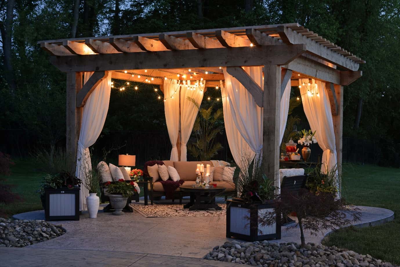 Top 5 Advantages of a Pergola. Wooden canopy with tulle curtains and cozy outdoor furniture and pillows