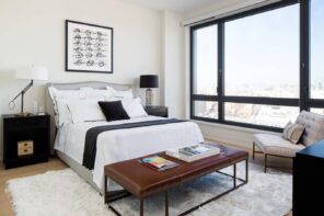 5 Tips For Turning Your Home Into A Rentalю Bright modern styled bedroom with brown leather ottoman