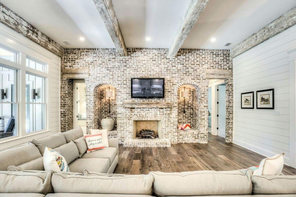 Brick Wall in the Living Room Stylish Interior. Exposed ceiling beams of the loft room with the TV and the fireplace 