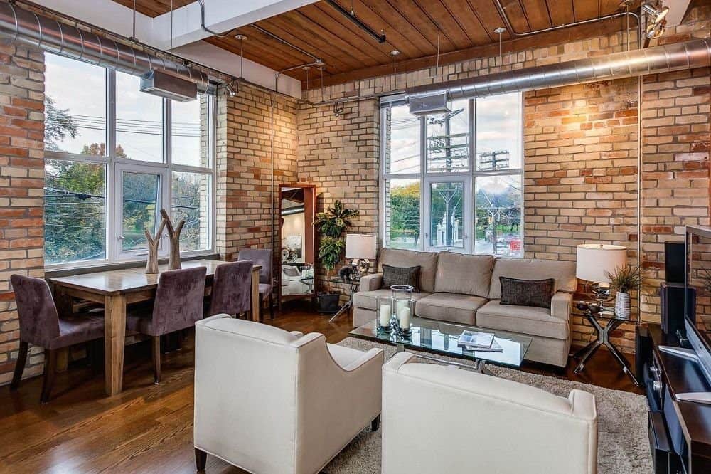 The living room with brick walls and exposed ventilation system