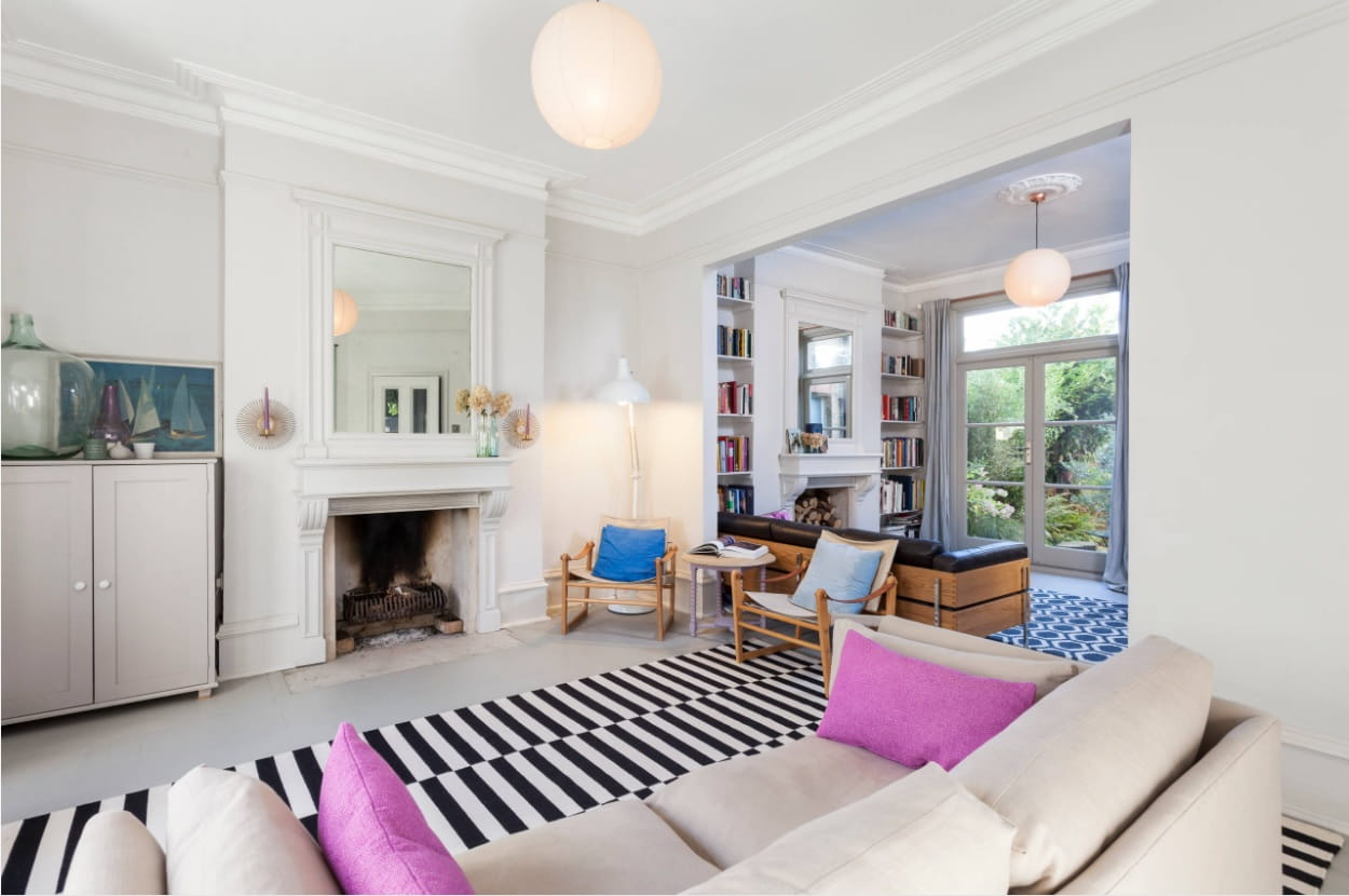 Zebra rug in the classic and casual styled living room with colorful accents in the form of pillows and armchairs