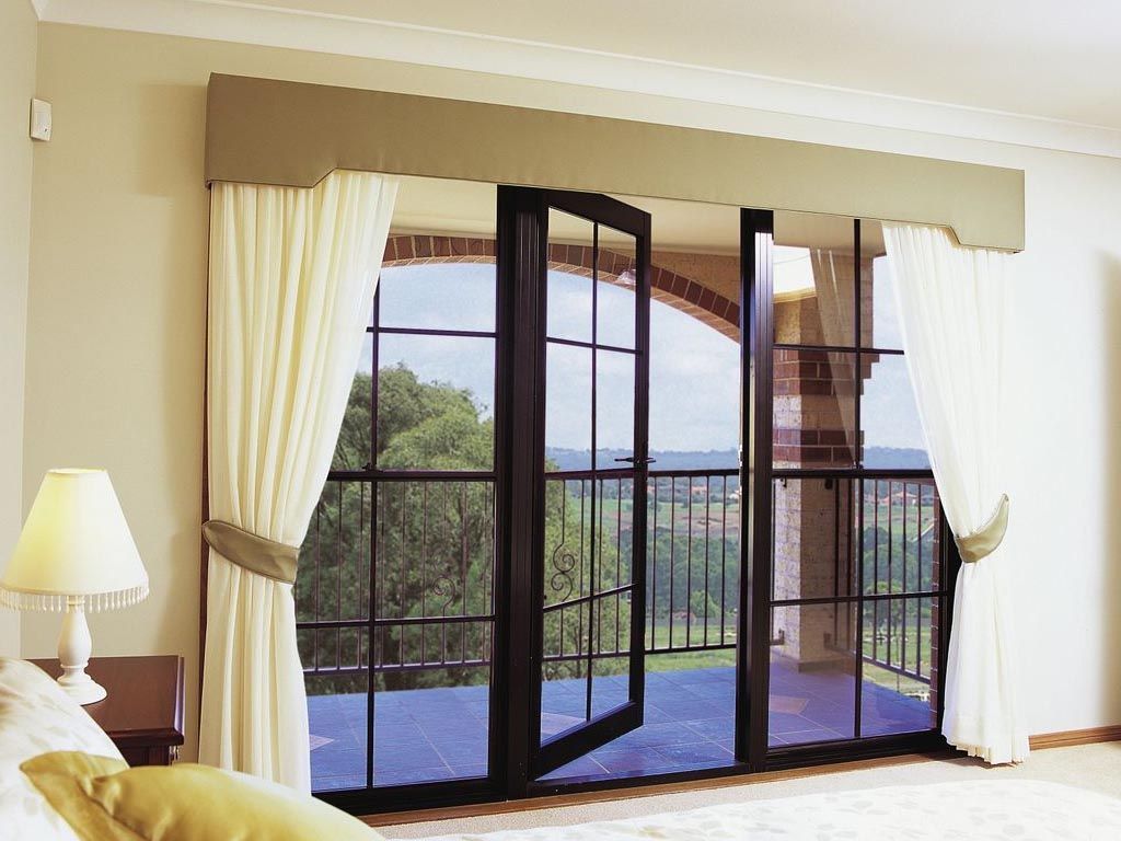 Choosing the Balcony Doors: Construction, Design, and Color. Black framed door with panoramic windows and metal inlays