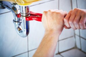 When Should You Call an Emergency Plumber Service. Fixing the pipe leaking with adjustable wrench