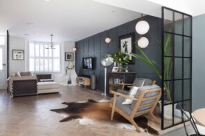 Living Room Interior 2022: Fashionable Design Trends & Ideas. Black accent wall for modern designed living room with pelt near the armchair