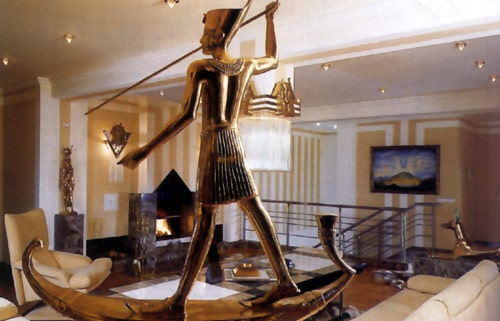 Egyptian Interion Design Style. The large statue of pharaoh in the yellow and white colored interior 