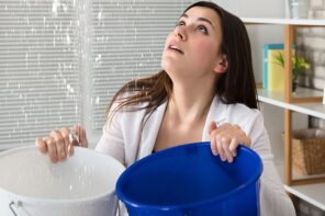 3 Immediate Actions to Take When Your Roof Is Leaking. The woman with two buckets collecting the falling water drops