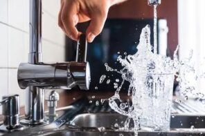 Beginner’s Guide: Choosing the Right Kitchen Faucet. The water spashes out of the glass at the double steel sink