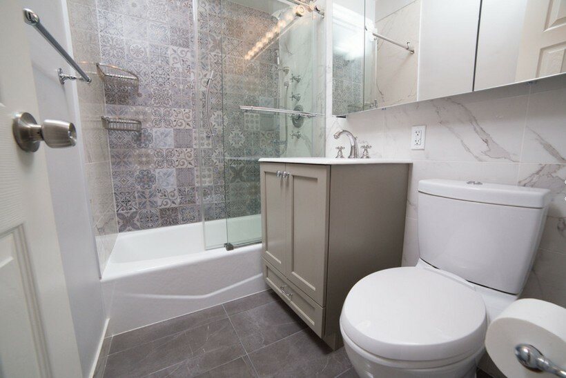 Morroccan tile at the accent wall of the shower with lower edge bathtub and mirroring cabinet