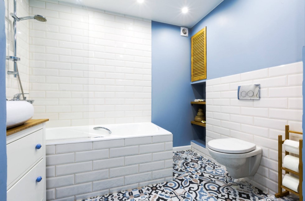 Blue colored walls and white metro tile facing of the walls and bathtub