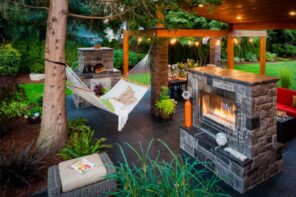 7 Design Tricks To Boost Your Home’s Curb Appeal. Outdoor patio zone with the fireplace and the hammock for decoration