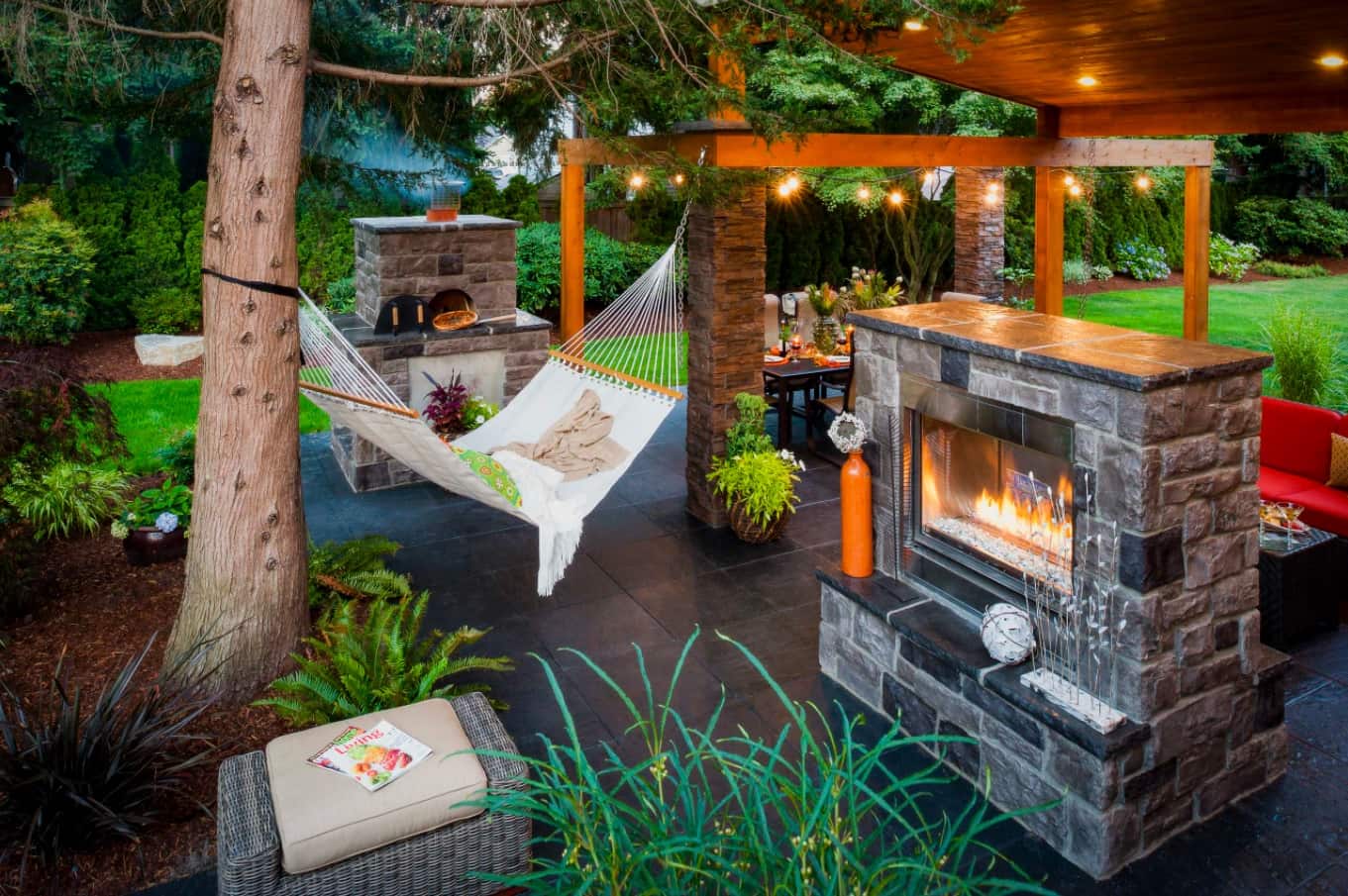 7 Design Tricks To Boost Your Home’s Curb Appeal. Outdoor patio zone with the fireplace and the hammock for decoration