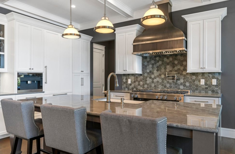 Pendant lights and brown splashback mosaic along with gray chairs in Classic kitchen interior
