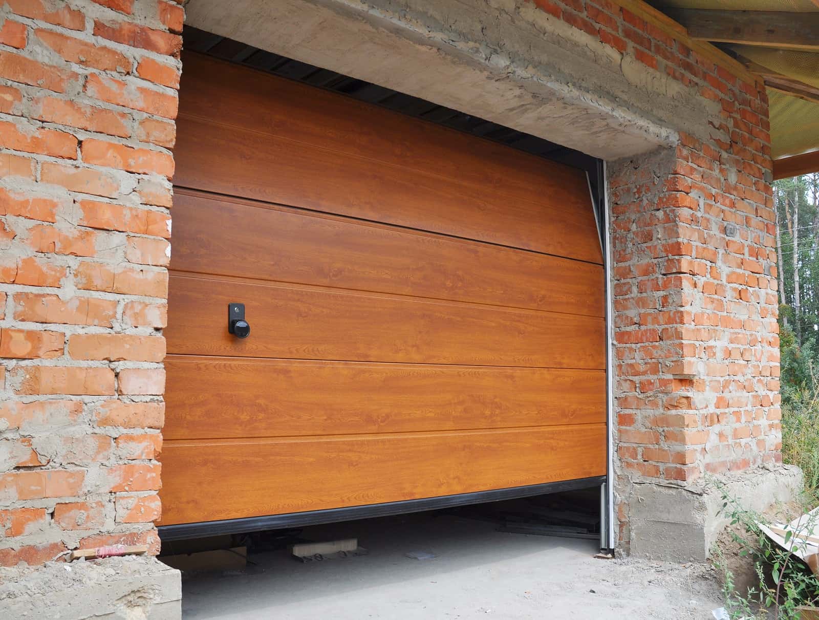 Should You Repair Or Replace Your Old Overhead Door? Brickwork surrounded door arch for wooden lifting construction