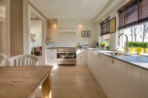 Easy and Creative Ideas to Upgrade Your Kitchen. Casual galley kitchen in light pastel color palette with natural wooden laminate on the floor