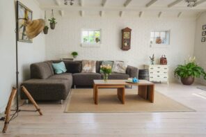 5 Redecorating Tips for Creative and Aesthetic Homes. Casual living room interior with open ceiling beams, whitewashed brickwork imitation and contrasting dark angular sofa