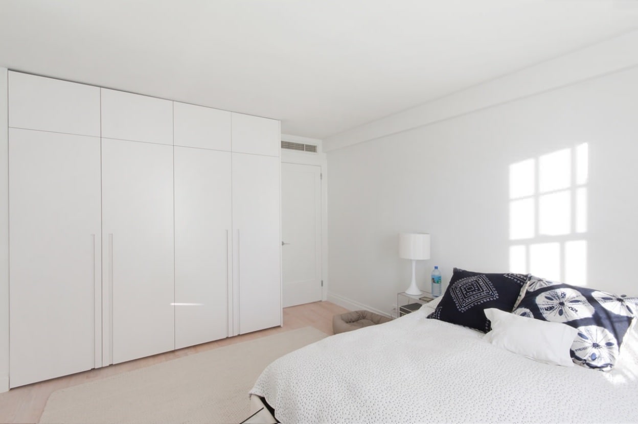 5 Easy Decluttering Hacks For Your New Home. Minimalistic casual bedroom in total white with the wardrobe and large platform bed 