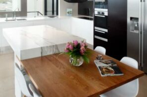 7 Ideas for Creating an Eat-in Kitchen for Entertaining. Modern contrasting designed kitchen with partly wooden partly plastic island and black appliances
