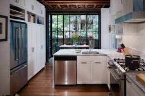 The Insider’s Guide - Dishwasher Installation Done Right. Classic L-shaped kitchen in the private house with white furniture, steel appliances and stunning panoramic sash window with black frame