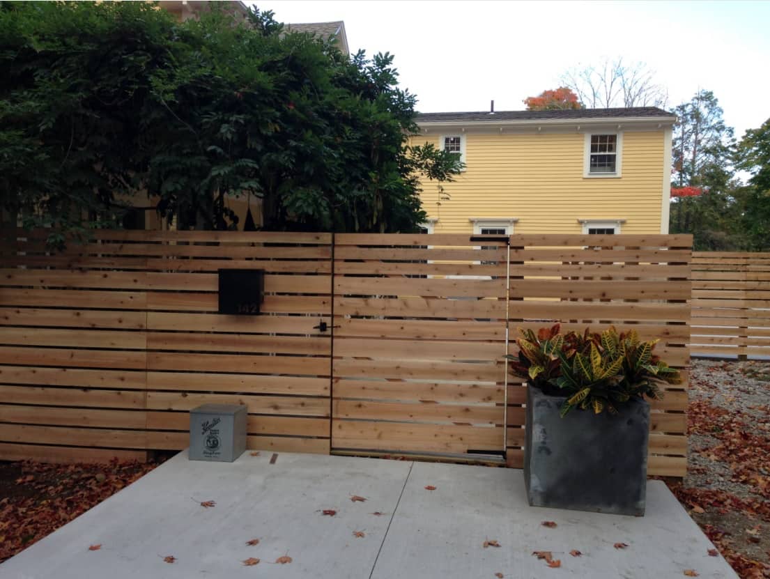 5 Popular Exterior Home Projects for Spring. Fashionable wooden fence and large concrete slabs to pave the driveway