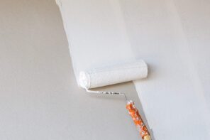 DIY Interior Paint: 7 Tips And Tricks For A Flawless Finish. Roller painting the wall in white