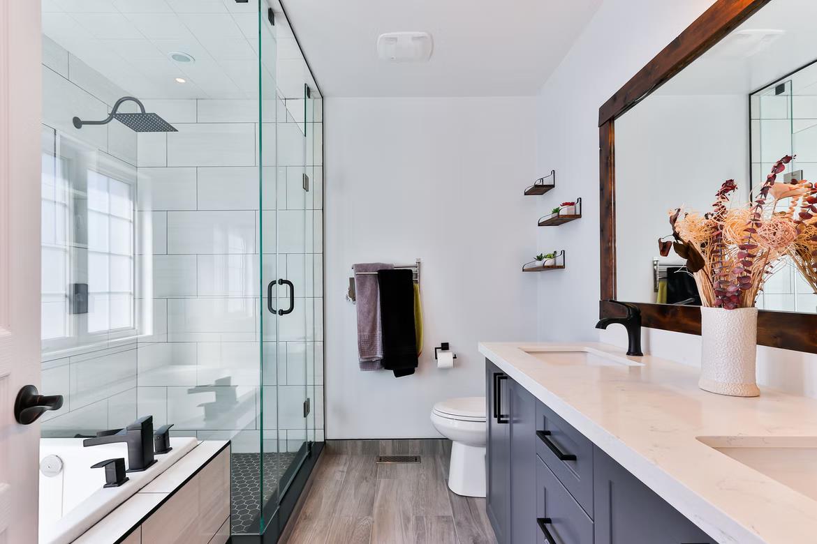 Decided To Renovate Your Bathroom? These Simple Tricks From Strip Drain Will Help You. Minimalistic interior with black wooden frame mirror, glass shower cabin with exquisite black fittings