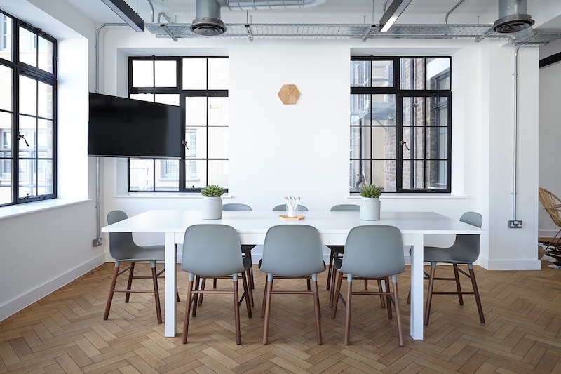 How Can I Make My Office Look Modern? TV-panel and large plastic table decorated with small trimmed plants