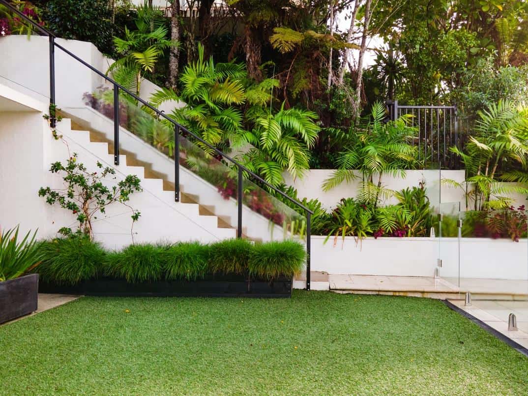 How To Redesign Your Garden And Make It More Comfortable. Neat trimmed grass and shrubs at the stairs to the top level