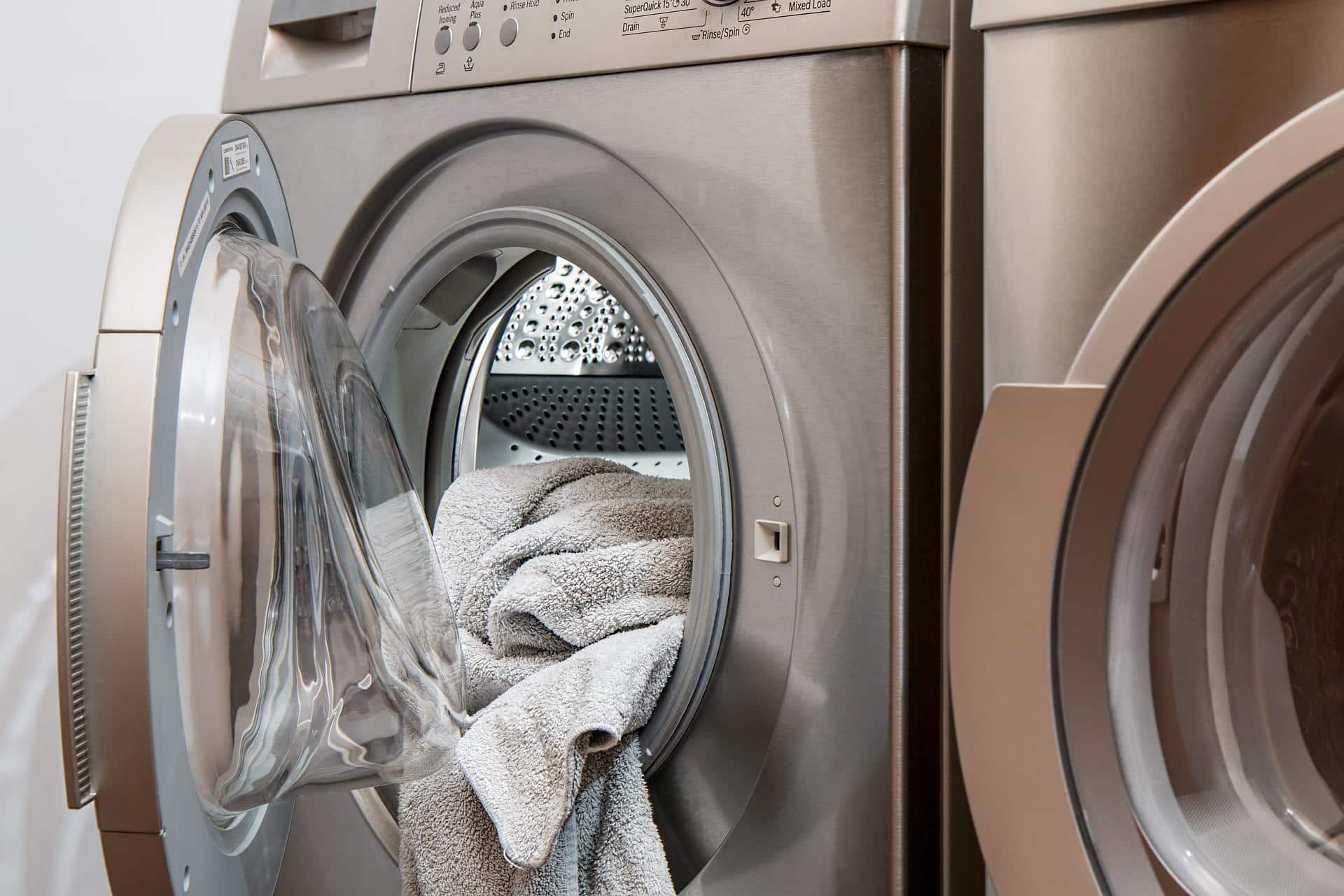 How to Make Laundry Day as Energy Efficient as Possible. The silver colored modern washing machine with the terry towel
